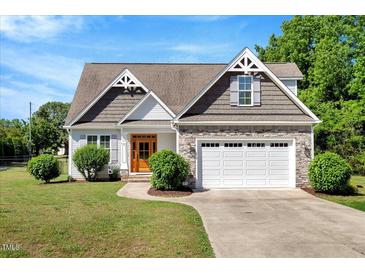 Charming home featuring a stone and vinyl facade, well-manicured lawn, and a two-car garage at 2062 Montgomery Dr, Franklinton, NC 27525