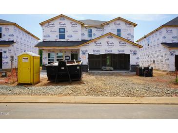 New home being built with Tyvek wrap and construction materials on the lot at 2238 Cherry Creek Rd, Haw River, NC 27258