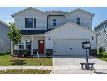 Charming two-story home featuring a red front door, a two-car garage, and a well-manicured lawn at 2238 Cherry Creek Rd, Haw River, NC 27258