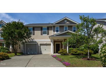 Charming two-story home featuring a two car garage and manicured landscaping at 310 Seymour Pl, Cary, NC 27519