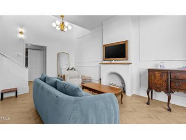 Bright living room featuring herringbone floors, a stylish sofa, and a decorative fireplace at 320 W Martin St # 205, Raleigh, NC 27601