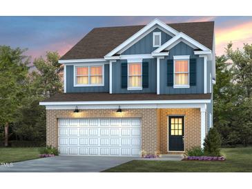 Charming two-story home with a brick and siding exterior, featuring a two-car garage and professionally landscaped yard at 425 Providence Springs Ln, Fuquay Varina, NC 27526