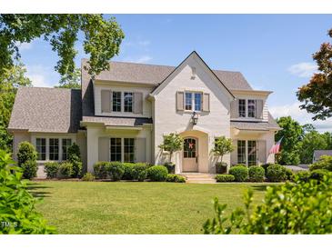 Stunning two-story painted brick home with mature trees, manicured lawn and beautifully trimmed shrubbery at 4404 Yadkin Dr, Raleigh, NC 27609