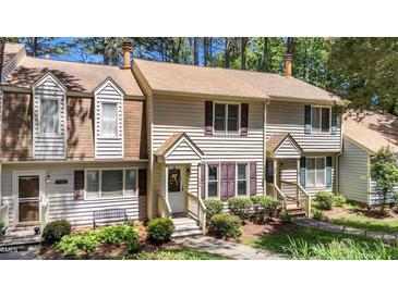 Charming townhouse with tan siding, manicured landscaping, and inviting front entryways at 704 Benchmark Dr, Raleigh, NC 27615