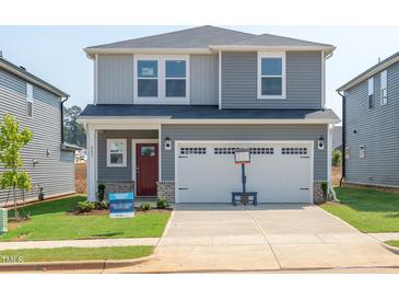 Charming two-story home featuring a spacious two-car garage, a red front door, and a well-manicured lawn at 809 Ottawa Dr, Garner, NC 27529