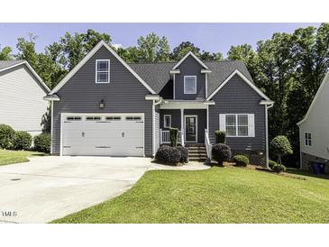 Charming home featuring a two-car garage, gray siding and manicured landscaping at 870 Live Oak Ln, Nashville, NC 27856