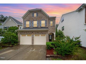 Charming two-story brick home featuring a two-car garage, manicured landscaping, and a welcoming front entrance at 1030 Thoughtful Spot Ln, Durham, NC 27703