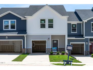 New construction townhome with a garage, modern design, and a well-manicured lawn at 1043 Winding Spring Dr, Mebane, NC 27302