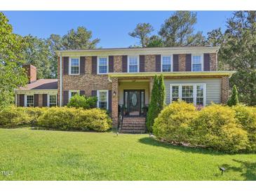 Charming two-story brick home with a well-manicured lawn and mature landscaping at 1315 Brigham Rd, Chapel Hill, NC 27517