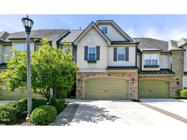 Charming townhome features a two-car garage, stone accents, and well-manicured landscaping at 140 Sunstone Dr, Cary, NC 27519
