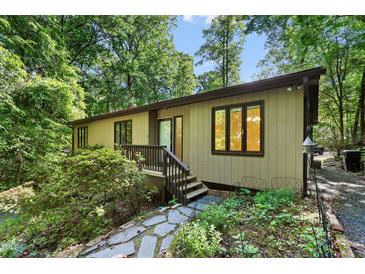 Charming home exterior with stone pathway, lush greenery and natural light throughout at 205 Bruton Dr, Chapel Hill, NC 27516