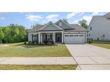 Charming single-story home featuring a well-manicured lawn and attached two car garage at 3034 Raddercrest Ct, Fuquay Varina, NC 27526