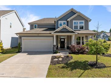 Charming two-story home featuring a gray facade, covered porch, two-car garage, and well-maintained landscaping at 325 Avery Glenn Way, Fuquay Varina, NC 27526