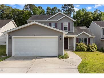 Charming two-story home with gray siding, a two-car garage, and beautifully manicured landscaping at 3816 Mike Levi Ct, Raleigh, NC 27610