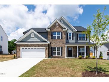 New two-story home featuring brick and gray siding, a two-car garage, and a well-manicured front lawn at 50 Rosewood Ln, Youngsville, NC 27596