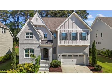Charming home with a painted brick facade, a manicured front yard, and an attached two-car garage at 5145 Landguard Dr, Raleigh, NC 27613