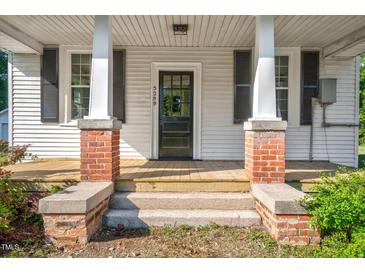 Charming front door with brick and concrete accents, flanked by black shuttered windows at 5299 Momeyer Way, Nashville, NC 27856