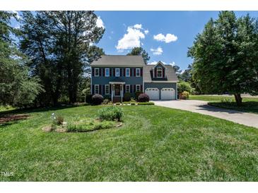 Charming two-story home features a well-manicured lawn and a two-car garage at 5812 N Beaver Ln, Raleigh, NC 27604