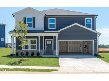 Charming two-story home with attached two-car garage and well-manicured lawn at 676 White Birch Ln, Angier, NC 27501