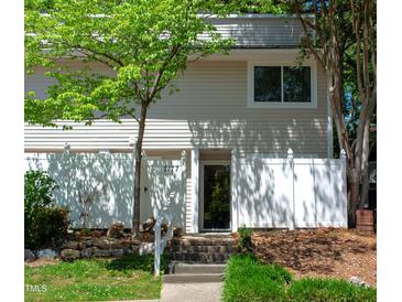 Charming townhouse with a white fence, mature landscaping, and welcoming front entrance at 7177 Sandy Creek Dr, Raleigh, NC 27615