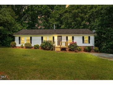 Charming single-story home with a well-manicured lawn and inviting front porch at 1004 Candlewood Cir, Siler City, NC 27344