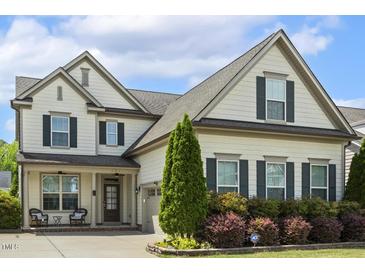 Charming two-story home with inviting front porch and well-manicured landscaping at 121 Martingale Dr, Holly Springs, NC 27540