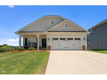 Charming single-Gathering home featuring a well-maintained lawn and an attached two-car garage at 124 Boomer St, Benson, NC 27504