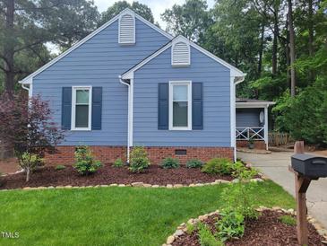 Charming blue house featuring dark blue shutters and nicely landscaped yard at 1304 Greenside Dr, Raleigh, NC 27609