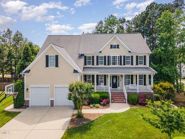 Charming two-story home with a welcoming front porch, beautiful landscaping, and a two car garage at 1952 Combine Cir, Apex, NC 27502