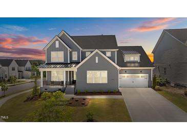 Beautiful two-story home boasts gray brick and siding, manicured landscaping, and an attached two-car garage at 236 Artisan Park Dr, Wake Forest, NC 27587