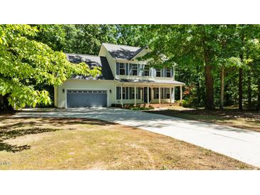 Inviting two-story home with blue shutters, a welcoming front porch, and a spacious driveway at 25 Ballinger Dr, Youngsville, NC 27596