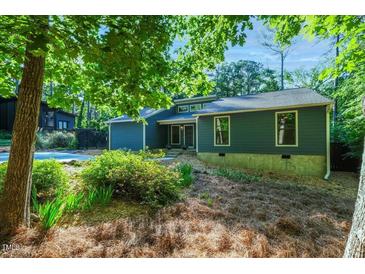 Charming single-story home featuring a blue exterior, manicured landscaping, and natural light at 2511 Bexley Ave, Durham, NC 27707