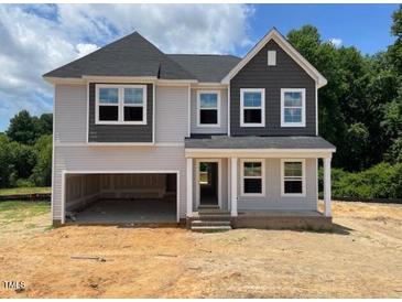 Two-story home with gray siding, a covered entryway, and an attached two-car garage at 316 Alice Trace Place, Angier, NC 27501