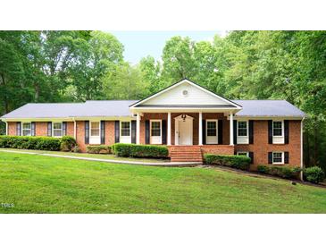 Charming brick home featuring a well-manicured lawn and mature trees at 3204 Manor Ridge Dr, Raleigh, NC 27603