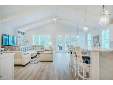 Bright open-plan living room with vaulted ceilings, modern furnishings, and access to the outdoor space at 328 Boone St, Chapel Hill, NC 27516