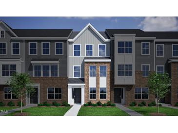 Charming townhome with gray and brick exterior, neat lawn, and welcoming entrance at 368 Chesapeak Commons St # 132, Garner, NC 27529