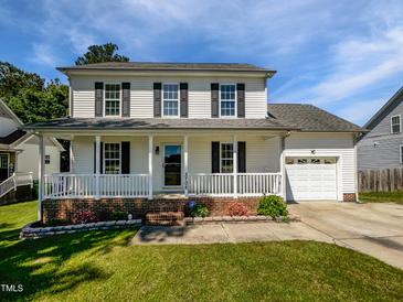 Charming two-story home featuring a welcoming front porch, attached garage, and well-maintained lawn at 3708 Mackinac Island Ln, Raleigh, NC 27610