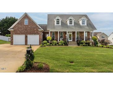 Charming brick home with a well-manicured lawn and attached two-car garage at 506 Wildwood Ln, Graham, NC 27253