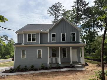 Charming two-story home featuring a welcoming front porch, gray siding, and large windows at 509 Olive Branch Rd, Durham, NC 27703