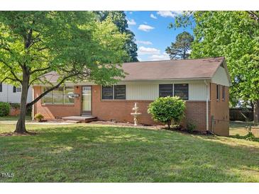 Charming brick home featuring mature trees and a well-maintained front yard at 717 Fairfield St, Burlington, NC 27215