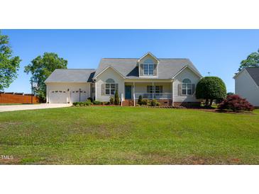 Charming two-story home with a manicured lawn, inviting porch, and attached two car garage at 1009 Open Field Dr, Garner, NC 27529
