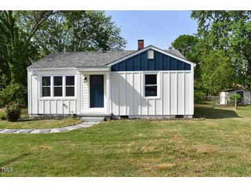 Charming home featuring white siding, a blue accent, and a well-manicured lawn at 102 Allen St, Graham, NC 27253