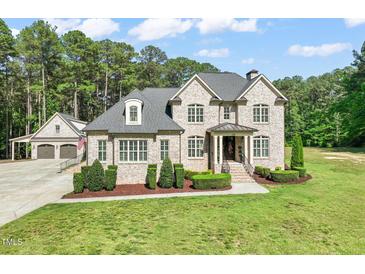 Stately brick home featuring manicured landscaping, a welcoming entrance, and attached garage at 120 Lu Tom Ln, Wendell, NC 27591