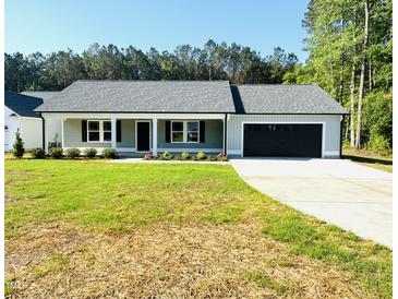 Charming single-story home boasts a well-manicured lawn and an attached two-car garage at 121 Earnest Way, Kenly, NC 27542