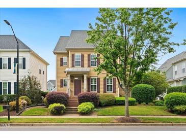 Charming two-story home featuring a well-manicured lawn, mature landscaping, and a welcoming front porch at 1328 Palace Garden Way, Raleigh, NC 27603