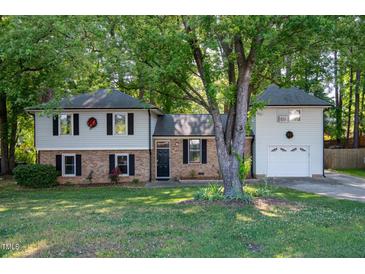 Charming two-story home with brick accents, well-maintained lawn, and mature trees offering shade and curb appeal at 1700 Laura Duncan Rd, Apex, NC 27502