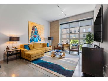 Bright living room features high ceilings, large windows, stylish decor, and a comfortable sectional sofa at 319 Fayetteville St, Raleigh, NC 27601