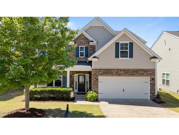 Charming two-story home with stone accents, blue shutters, a well-manicured lawn, and an attached two-car garage at 3936 White Kestreg Dr Dr, Raleigh, NC 27616