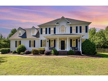 Traditional two-story home with a welcoming front porch, black shutters, and manicured landscaping at 4117 Stansted Dr, Fuquay Varina, NC 27526