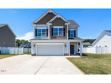 Charming two-story home with a two-car garage and well-manicured lawn under a clear blue sky at 43 Jonalker Ct, Clayton, NC 27520